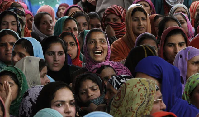 A Kashmiri woman supporter of the Peoples Democratic Party (PDP) laughs as she attends an election campaign rally on the outskirts of Srinagar, India, Thursday, April 17, 2014. Several separatist organizations have jointly appealed to the people of Jammu and Kashmir to boycott the Indian parliamentary elections. (Photo by Mukhtar Khan/AP Photo)
