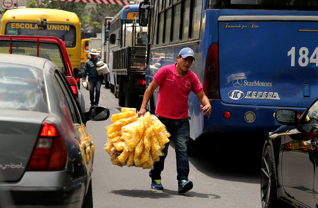 A man sells chips at a traffic junction in Quito, Ecuador, February 18, 2017. (Photo by Mariana Bazo/Reuters)