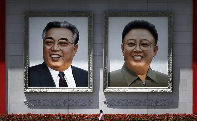 A woman is dwarfed as she walks past giant portraits of the late North Korean leaders Kim Il Sung, left, and Kim Jong Il at the Kim Il Sung Square Saturday, May 7, 2016 in Pyongyang, North Korea. (Photo by Wong Maye-E/AP Photo)