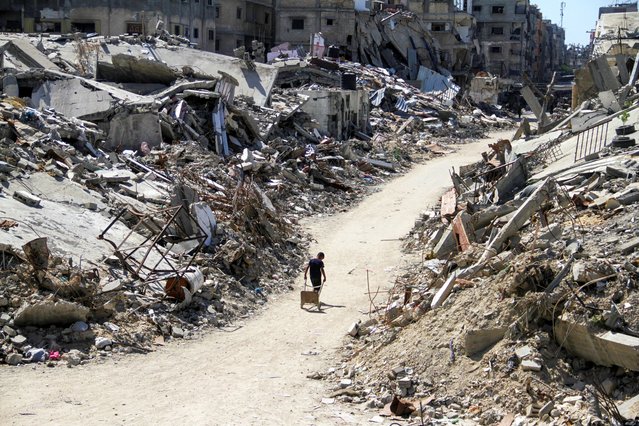 A Palestinian walks among the rubble of damaged buildings, which were destroyed during Israel's military offensive, amid the ongoing conflict between Israel and Hamas, in Beit Lahia in the northern Gaza Strip, on June 12, 2024. (Photo by Mahmoud Issa/Reuters)