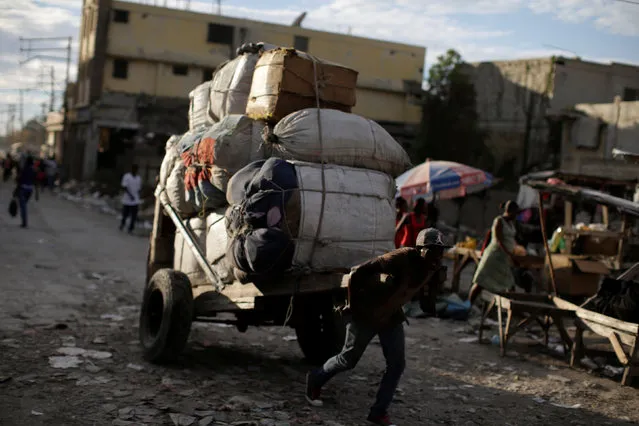 A man pulls a wheelbarrow in a street market in Port-au-Prince, Haiti, February 14, 2017. (Photo by Andres Martinez Casares/Reuters)