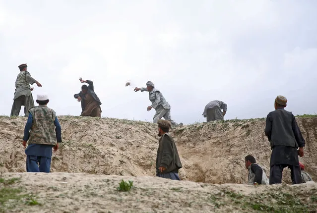 Afghanis from Abi Barik village throw stones at a man from a neighboring village after police fired in the air to disperse a crowd that had rushed toward a truck carrying aid near the site of Friday's landslide that buried Abi Barik village in Badakhshan province, northeastern Afghanistan, Tuesday, May 6, 2014. Many villagers from Abi Barik have complained that aid has been slow to arrive while officials have said their efforts have been complicated by villagers from nearby areas coming to get handouts. (Photo by Massoud Hossaini/AP Photo)