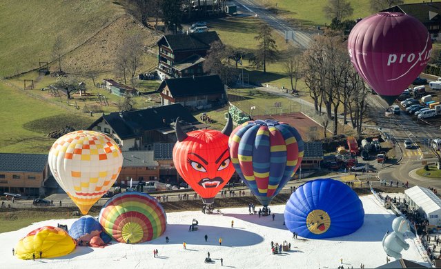 Balloons take part in the 44th International Hot Air Balloon Festival in Chateau-d'Oex, Switzerland, on January 25, 2024. (Photo by Denis Balibouse/Reuters)