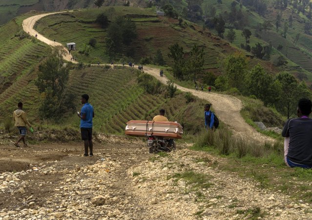 A motorcycle taxi navigates a rocky road, transporting a coffin for a family who live in the Kenscoff community, in the foothills of the Chaîne de la Selle mountain range, on the outskirts of Port-au-Prince, Haiti, May 14, 2024. (Photo by Ramon Espinosa/AP Photo)