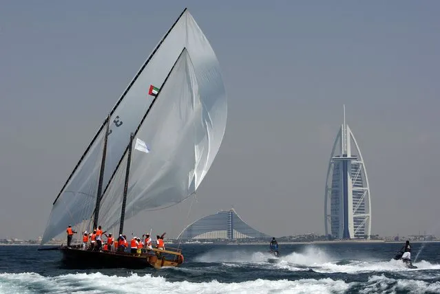 Crew members of a traditional wooden boat, or dhow, celebrate victory as they sail towards the finishing line in the Al Gaffal race, a long-distance dhow sailing race, near Sir Bu Nuayr near Sharjah May 18, 2014. (Photo by Martin Dokoupil/Reuters)