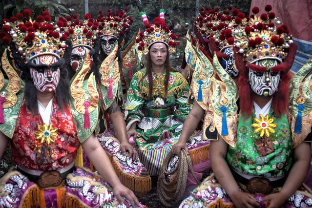 Members of Wuxing Ba Jiang Tuan, a Taiwanese folk troupe, wait to perform their ritual performance celebrating the 50th anniversary of the Minxiong Xutian Temple on April 22, 2023, in Chiayi, Taiwan. Ba Jiang Tuan, originated from Chinese folk beliefs and refers to eight generals who were said to have performed exorcisms of evil spirits. Throughout history, the generals became respected as gods of the underworld and bodyguards of the gods. Today, Ba Jiang Tuan folk troupes perform across Taiwan and their performances are said to capture ghosts and evil spirits bringing safety and good luck to the temple and its believers. Once the performers have completed their face makeup and costume, they are not permitted to speak as they have taken on the role of a god. (Photo by Chris McGrath/Getty Images)