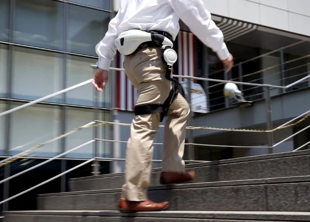A Honda Motor Co employee demonstrates the company's new Walking Assist Device, which for those with weakened leg muscles who are still able to walk, during its unveiling in Tokyo July 21, 2015. Honda announced the company will lease the Walking Assist Device to hospitals in Japan that provide rehabilitation training / physical therapy in the area of walking on November, 2015. (Photo by Toru Hanai/Reuters)