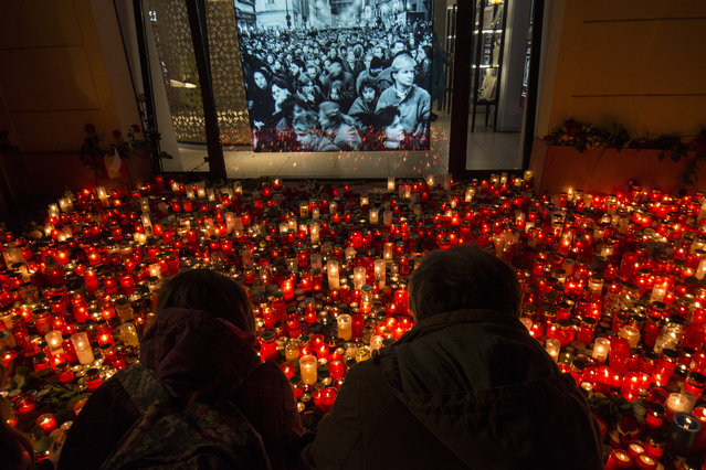 People place candles at a memorial to commemorate the 30th anniversary of the so-called Velvet Revolution on November 17, 2019 in Prague. The peaceful Velvet Revolution toppled the Communist regime in former Czechoslovakia 30 years ago, paving the way for democratic and economic reforms in the former Soviet satellite. (Photo by Michal Cizek/AFP Photo)
