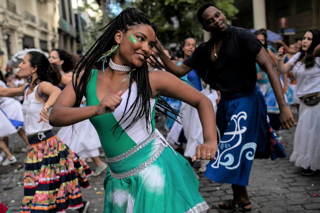 A woman dances during a rehearsal by the group “Tambores de Olokun” in Rio de Janeiro, Brazil, Sunday, April 17, 2022. The Brazilian municipalities of Rio de Janeiro and Sao Paulo postponed the traditional parades of the carnival samba schools to April 22 - 23, as a result of the COVID-19 pandemic. (Photo by Bruna Prado/AP Photo)