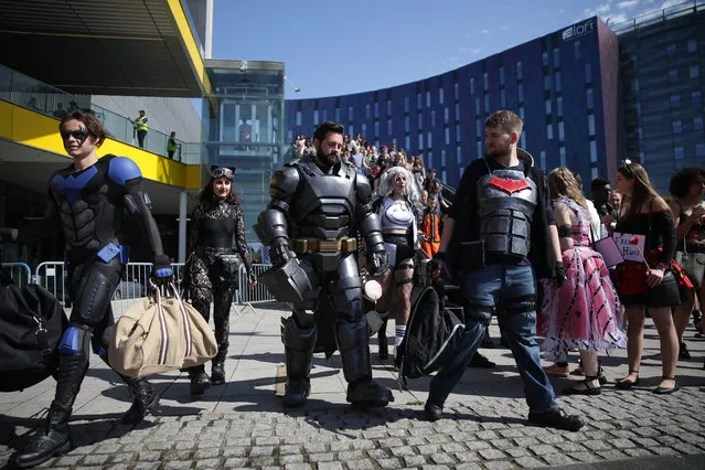 Conventiongoers dressed as super heros are seen arriving on the second day of the London “MCM Comic Con” at the ExCel centre in east London, on May 27, 2017. The comic convention is the largest of it' s type in the UK and sees fans and enthusiasts flock to the ExCel centre to meet their heros, browse merchandise and see previews of upcoming releases. (Photo by Daniel Leal-Olivas/AFP Photo)