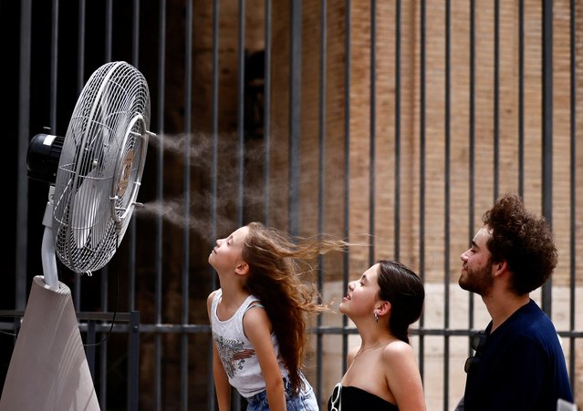 People stand in front of a cooler installed around the Colosseum amid a heatwave in Rome, Italy, on June 21, 2024. (Photo by Yara Nardi/Reuters)