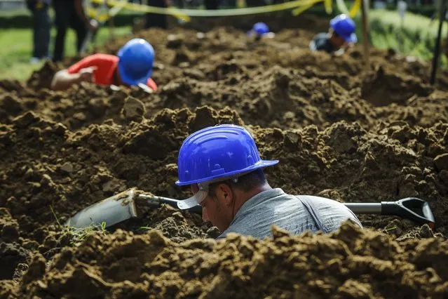 Work in progress during the first National Grave Digging Competition organized by the National Association of Graveyard Operators and Maintainers of Hungary (MTFE) in the public cemetery of Debrecen, 226 kms east of Budapest, Hungary, 03 June 2016. (Photo by Zsolt Czegledi/EPA)