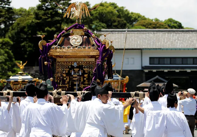 Participants dressed in ancient Japanese costumes handle portable shrines as they take part in a parade at the Imperial Palace during the Sanno Festival in Tokyo, Japan June 10, 2016. (Photo by Toru Hanai/Reuters)