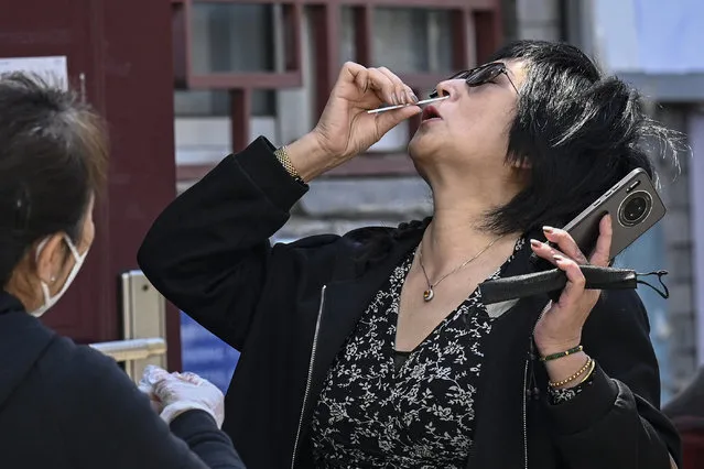 A woman takes a rapid antigen test for the Covid-19 coronavirus at a community centre in Beijing on May 14, 2022. (Photo by Jade Gao/AFP Photo)