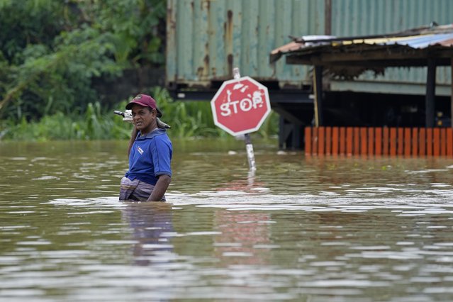 A man wades through flood waters in Kelaniya, a suburb of Colombo, Sri Lanka, Monday, June 3, 2024. Sri Lanka closed schools on Monday as heavy rains triggered floods and mudslides in many parts of the island nation, killing at least 10 people while six others have gone missing, officials said. (Photo by Eranga Jayawardena/AP Photo)