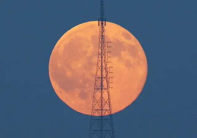 A full moon, known as the Blue Moon, rises behind a telecommunication tower over the Camlica Hill in Istanbul, Turkey, July 31, 2015. (Photo by Murad Sezer/Reuters)