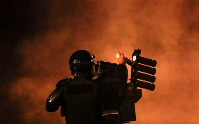 A Lebanese riot policeman loads tear gas canisters into a launcher during clashes with anti-government protesters in the central downtown district of the Lebanese capital on January 18, 2020. (Photo by Anwar Amro/AFP Photo)