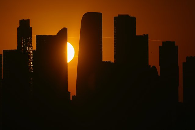 The sun rises over the Moscow-City business district in Moscow, Russia, Thursday, October 3, 2024. (Photo by Pavel Bednyakov/AP Photo)