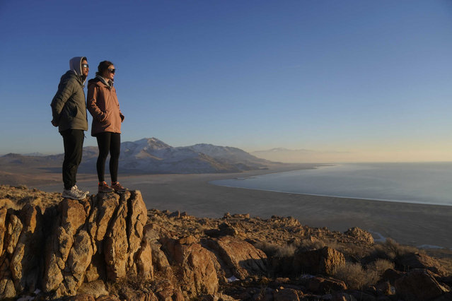 Antelope Island State Park visitors view the the receding edge of the Great Salt Lake Friday, January 28, 2022, at Antelope Island, Utah. The largest natural lake west of the Mississippi is shrinking past its lowest levels in recorded history, raising fears about toxic dust, ecological collapse and economic consequences. But the Great Salt Lake may have some new allies: conservative Republican lawmakers. (Photo by Rick Bowmer/AP Photo)