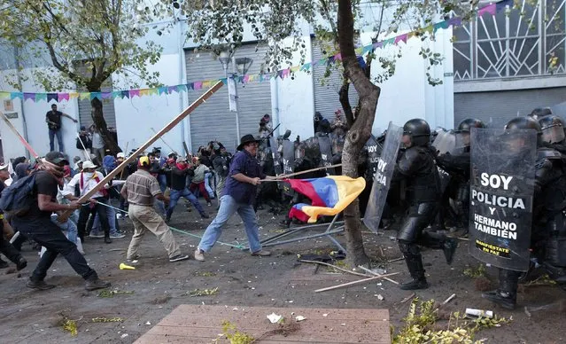 Demonstrators holding an Ecuadorean flag clash with police during a protest in Quito, Ecuador, August 13, 2015. (Photo by Guillermo Granja/Reuters)