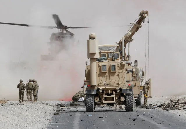 U.S. troops assess the damage to an armoured vehicle of NATO-led military coalition after a suicide attack in Kandahar province, Afghanistan August 2, 2017. (Photo by Ahmad Nadeem/Reuters)