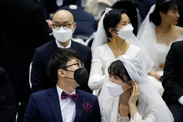 Couples wearing masks for protection from the new coronavirus, attend a mass wedding ceremony of the Unification Church at Cheongshim Peace World Centre in Gapyeong, South Korea, February 7, 2020. Mass weddings are a well-known feature of the South Korea-based church, but the spread of the new coronavirus has cast a pall over many public events. (Photo by Heo Ran/Reuters)
