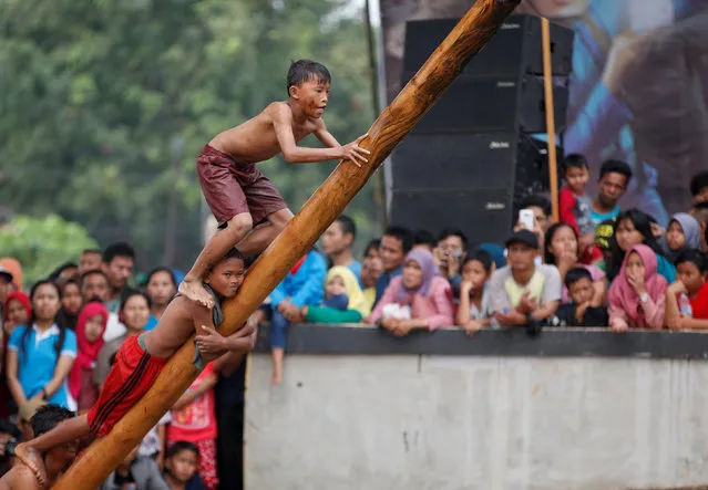 Boys climb a greased pole placed over a river to win prizes during Independence Day celebrations in Jakarta, Indonesia August 17, 2017. (Photo by Darren Whiteside/Reuters)