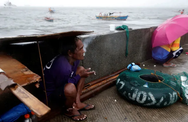 Fishermen take temporary shelter on a sidewalk due to bad weather brought by Typhoon Nepartak near Manila Bay, Philippines July 8, 2016. (Photo by Erik De Castro/Reuters)