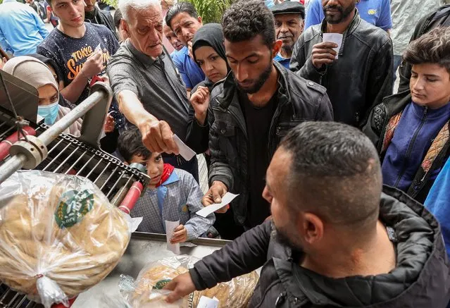 People queue to buy bread outside a bakery in Beirut, Lebanon on April 12, 2022. (Photo by Mohamed Azakir/Reuters)