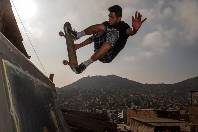 Willy Quispe manoeuvrers his skateboard on the ramp built at his house on top of a hill in the district of Villa María del Triunfo, on the southern outskirts of Lima, on June 20, 2022. A “U”-shaped ramp which measures 10 metres long by four metres wide and was built before the coronavirus pandemic in the back of their house, is a dream come true for the modest skaters. (Photo by Ernesto Benavides/AFP Photo)