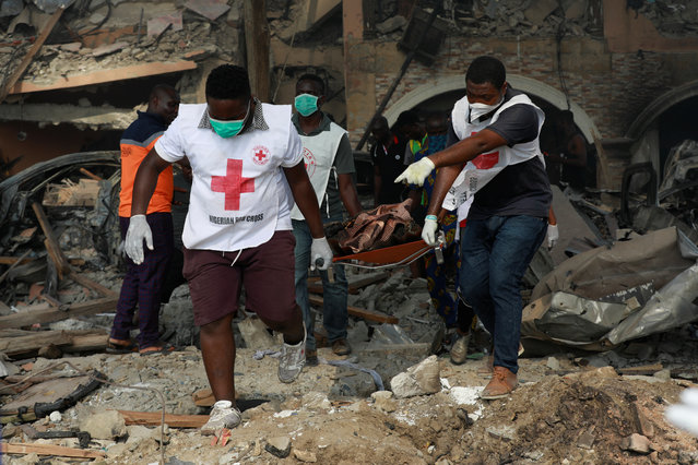 Paramedics carry a stretcher containing the body of a victim from one of the collapsed buildings at the scene of the pipeline explosion at Abule Ado in Lagos, Nigeria on March 15, 2020. (Photo by Temilade Adelaja/Reuters)