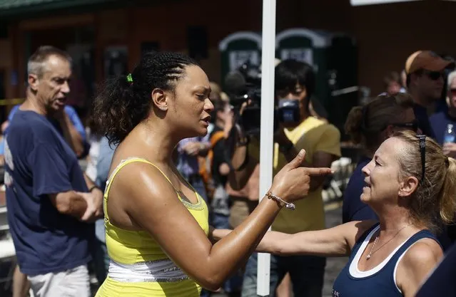 Sondra Fifer (C) confronts demonstrators supporting Ferguson Police officer Darren Wilson during a rally in St. Louis, Missouri August 23, 2014. Demonstrators in Ferguson, Missouri, gathered in intense heat on Saturday to pray and mark two weeks since a white police officer shot dead an unarmed black teenager, while supporters of the officer said in a separate rally miles away that the shooting was justified. (Photo by Joshua Lott/Reuters)