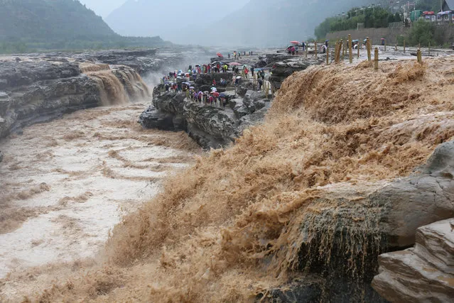 Tourists visit the Hukou waterfall on the Yellow river in Ji county, Linfen city, Shanxi province, China on September 5, 2017. (Photo by Imaginechina/Rex Features/Shutterstock)