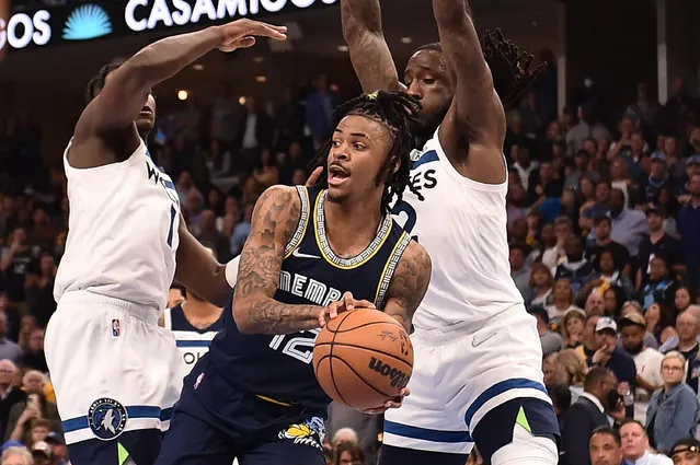 Ja Morant #12 of the Memphis Grizzlies looks to pass against Anthony Edwards #1 and Taurean Prince #12 of the Minnesota Timberwolves during Game Five of the Western Conference First Round NBA Playoffs at FedExForum on April 26, 2022 in Memphis, Tennessee. (Photo by Justin Ford/Getty Images)
