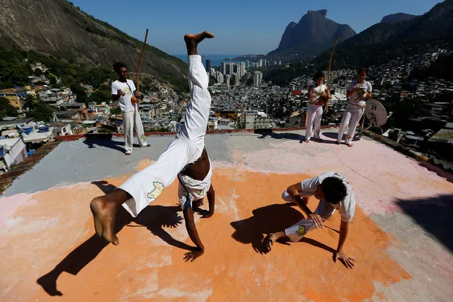 Members of the Acorda Capoeira (Awaken Capoeira) group perform on a rooftop in the Rocinha favela in Rio de Janeiro, Brazil, July 24, 2016. (Photo by Bruno Kelly/Reuters)