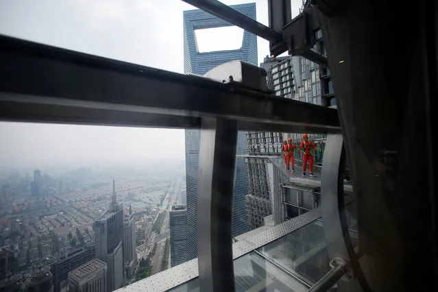 Jin Mao employees walk 340 meters above the ground around the newly opened Jin Mao tower skywalk in Shanghai, China, July 28, 2016. (Photo by Aly Song/Reuters)