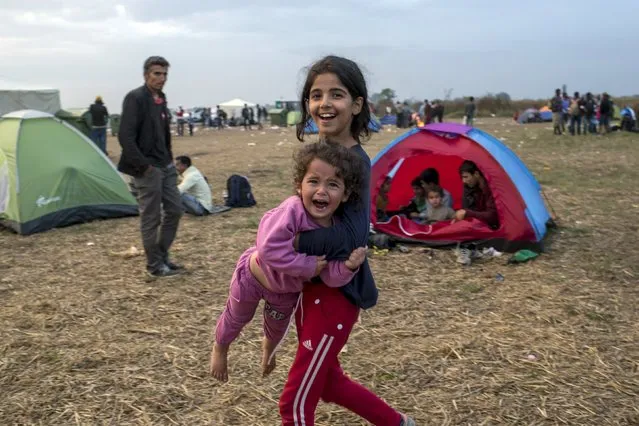 A migrant girl carries a child after crossing into Hungary from the border with Serbia on a field near the village of Roszke, September 5, 2015. (Photo by Marko Djurica/Reuters)