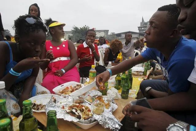 Attendees eat during the Festival des Grillades, in the yard of the Culture Palace of Abidjan, September 6, 2015. (Photo by Luc Gnago/Reuters)