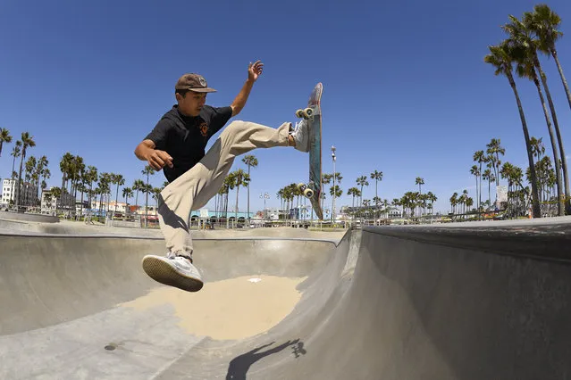 Soma Sugiyama, of Japan, attempts a trick as some of the skate park is still filled with sand to deter skaters at Venice Beach during the coronavirus outbreak, Wednesday, May 13, 2020, in Los Angeles. Los Angeles County reopened its beaches Wednesday in the latest cautious easing of coronavirus restrictions that have closed most California public spaces and businesses for nearly two months. (Photo by Mark J. Terrill/AP Photo)