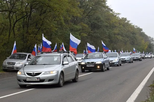 A motorcade with Russian national flags drive during celebrations marking the incorporation of the Donetsk region into Russia in Donetsk, Ukraine, Friday, September 30, 2022. (Photo by AP Photo/Stringer)