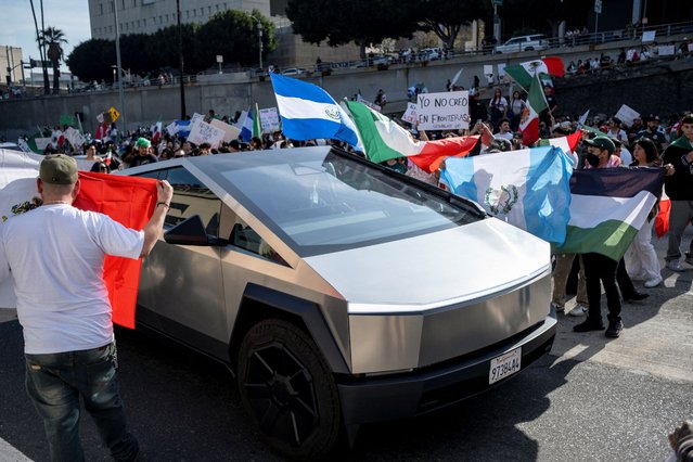 Protestors surround a Tesla Cybertruck as they march along U.S. Route 101 during a protest against arrests and deportations of migrants by U.S. government agencies in Los Angeles, California, U.S. February 2, 2025. (Photo by Joel Angel Juarez/Reuters)