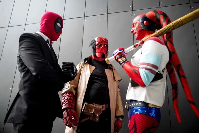 Cosplayers dressed as Deadpool, Hellboy, and Harley Quinn attend the MCM Comic Con at ExCeL exhibition centre in London on October 28, 2017. (Photo by Tolga Akmen/AFP Photo)