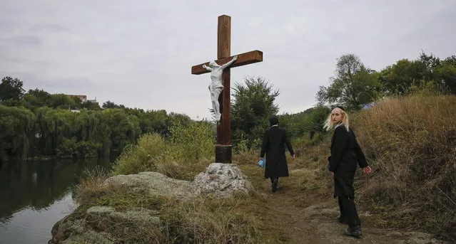 Orthodox Jewish children walk past a Chritian cross while celebrating Rosh Hashanah in Uman, about 200 km south of Kiev, Ukraine, 13 September 2015. Every year, thousands of Orthodox Bratslav Hasidic Jews from different countries gather in Uman to mark Rosh Hashanah, Jewish New Year, near the tomb of Rabbi Nachman, a great grandson of the founder of Hasidism.  (Photo by Roman PilipeyEPA)