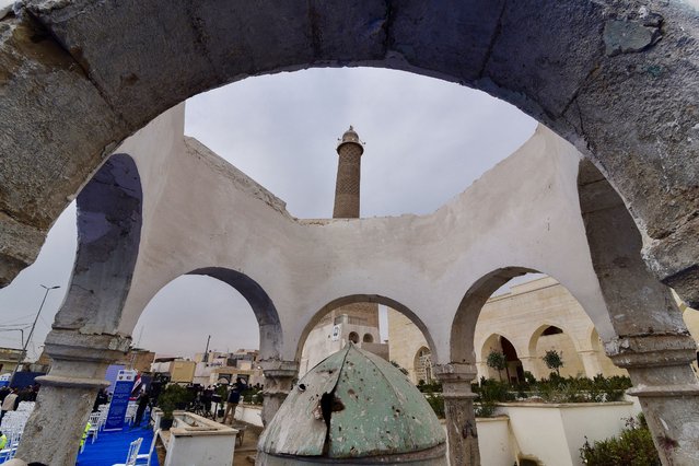 A picture shows a view of the historic Great Mosque of al-Nuri with its “Al-Hadba” leaning minaret dating back to the 12th century, in old Mosul on February 5, 2025, during a ceremony celebrating the final phases of of restoration work on heritage monuments in the city that was damaged during the fight with the Islamic State (IS) group. Eighty percent of Mosul's old city was destroyed in the fight against IS, and more than 12,000 tons of rubble was removed for a UNESCO restoration project, which included the famous Al-Hadba or "hunchback" leaning minaret and its historic Al-Nuri Mosque, Al-Tahira and Our Lady of the Hour churches, and 124 heritage houses. (Photo by Zaid Al-Obeidi/AFP Photo)