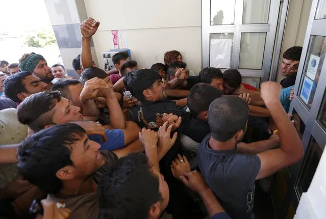 Migrants wrestle to buy train ticket at the train station in Beli Manastir, Croatia September 18, 2015. (Photo by Laszlo Balogh/Reuters)