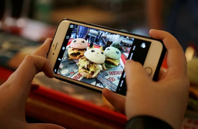 A customer takes a picture of Pokeburgs, hamburgers in the form of Pokemon characters, at Down N' Out Burger restaurant in Sydney, Australia, August 26, 2016. (Photo by Jason Reed/Reuters)