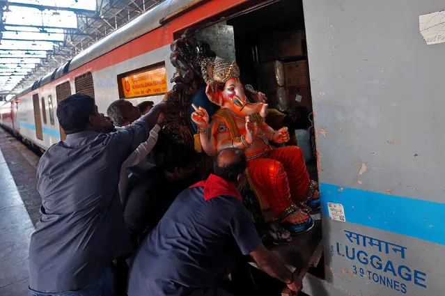 People load an idol of Hindu elephant god Ganesh, the deity of prosperity, onto a train at a railway station in Mumbai, India August 29, 2016. (Photo by Danish Siddiqui/Reuters)