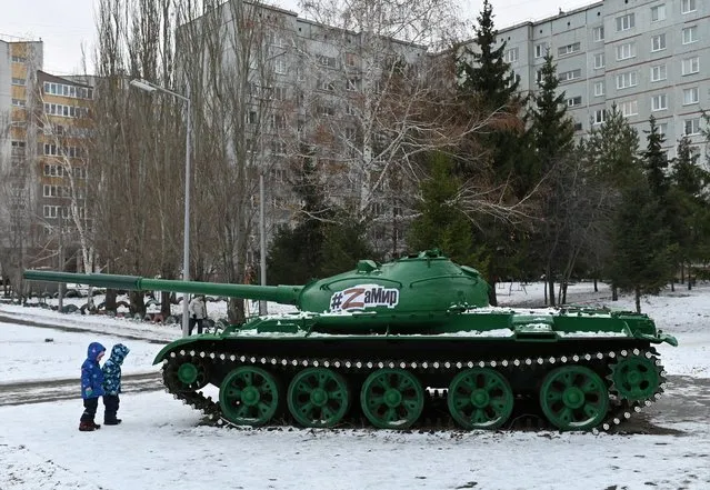 Children play near a monument to the Soviet tank T-62 in the courtyard of an apartment building in Omsk, Russia on November 9, 2022. (Photo by Alexey Malgavko/Reuters)