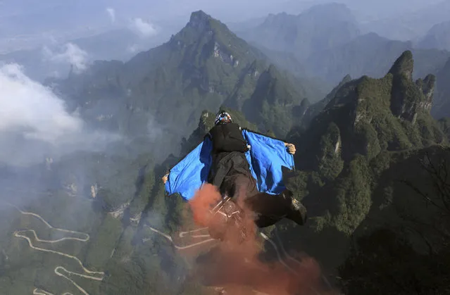 A contestant flies during a World Wingsuit Championship at Tianmen Mountain near Zhangjiajie, Hunan province, October 17, 2012. (Photo by Reuters/China Daily)