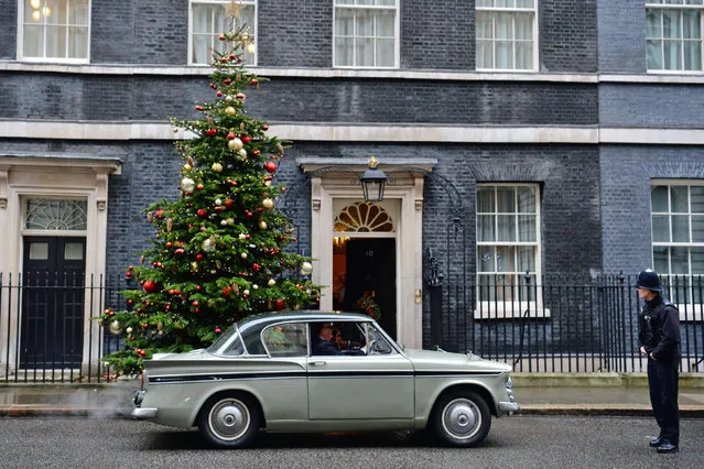 A police officer looks at Greg Knight MP arriving in Downing Street, London, England on December 21, 2017 in a 1961 Sunbeam Rapier car. (Photo by Victoria Jones/PA Images via Getty Images)